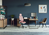 Private office space equipped with a pink Steelcase Series 2 Task chair, sitting in front of a West Elm Greenpoint Private Office Desk and a brown armless West Elm Sterling Guest Chair.